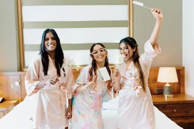 Three bridesmaids in robes laughing during a bridal shower