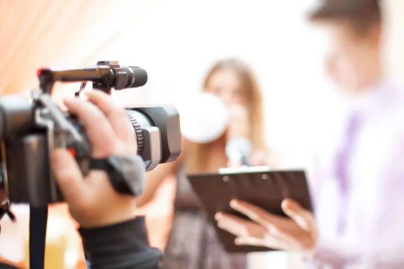 Videographer filming a wedding party with a handheld camera
